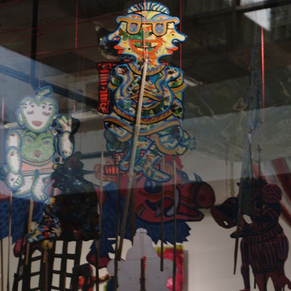 Painted wayang figures seen through the gallery glass